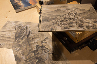 Wildlife artist sketching animal studies as the foundation for large oil paintings